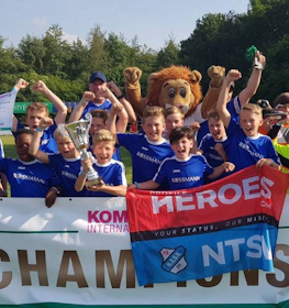 Equipe de futebol jovem comemorando a vitória com um troféu no torneio Slagharen Trophy.