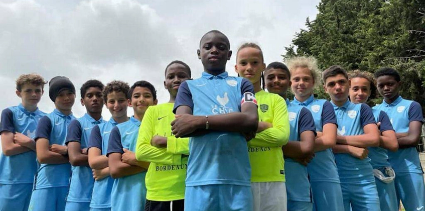 Equipe de futebol juvenil diversificada posando com confiança para a Copa de Futebol do Mediterrâneo.