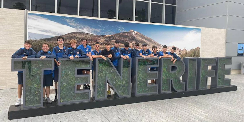 Soccer team posing in front of the TENERIFE sign at the Canarias Cup.
