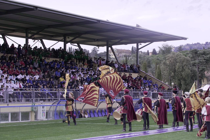 Medieval flag bearers performing at the Florence Cup football tournament before an audience.