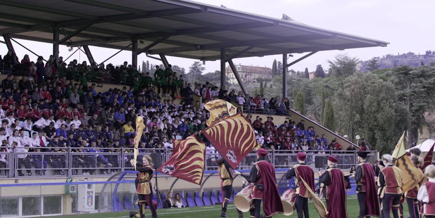Porte-drapeaux médiévaux se produisant au tournoi de football Florence Cup devant un public.