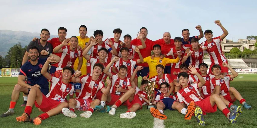 Радостная футбольная команда празднует с трофеем на стадионе