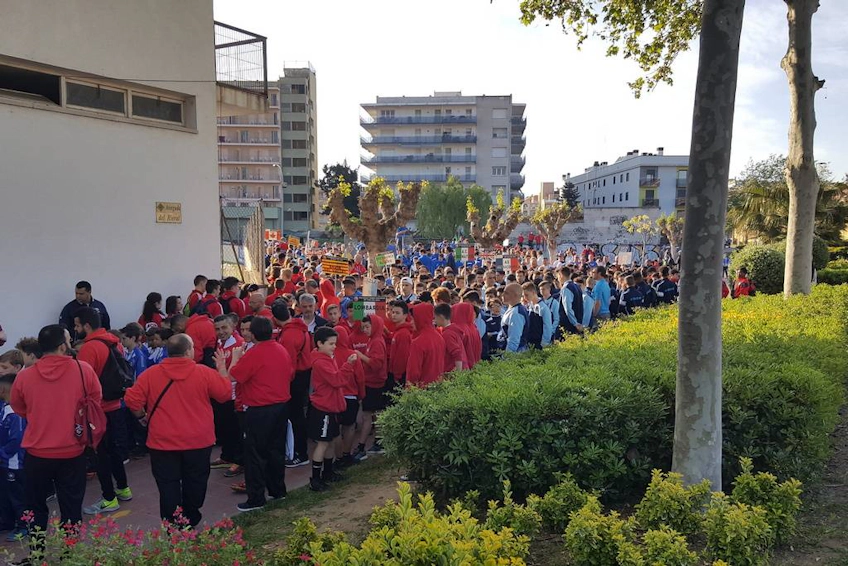 Çeşitli formalar giymiş genç futbol takımlarının Trofeo Vila de Lloret turnuvası için şehir ortamında toplandığı büyük kalabalık.