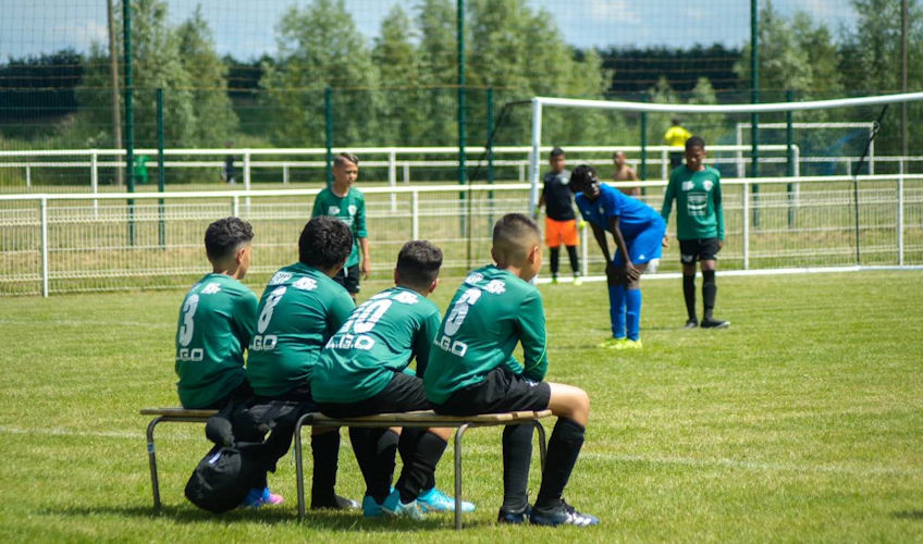 Yeşil formalı futbolcular, Paris Val d'Europe Kupası'nda bir maçı izlerken bankta oturuyor.