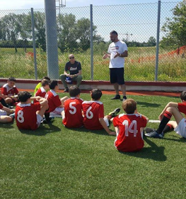 Coach teaching young footballers at the Riviera Summer Cup tournament