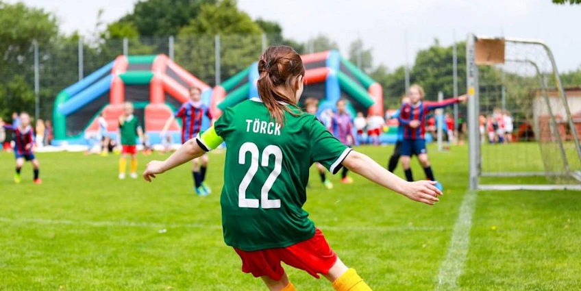 Laola Cup turnuvasında yeşil formayla 22 numaralı kadın futbolcu şut çekiyor