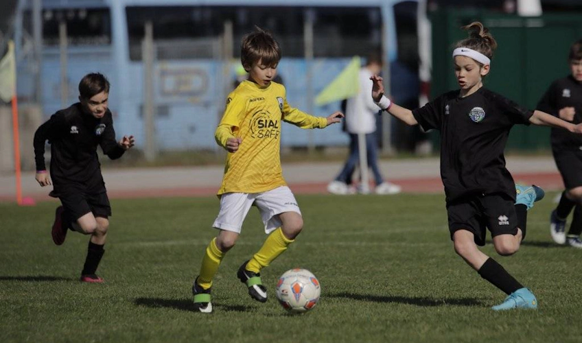 Sarı ve siyah üniformalı genç futbolcular Trofeo Riviera futbol turnuvasında oynuyor