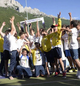 Enfants célébrant une victoire au festival de football Val di Fassa.