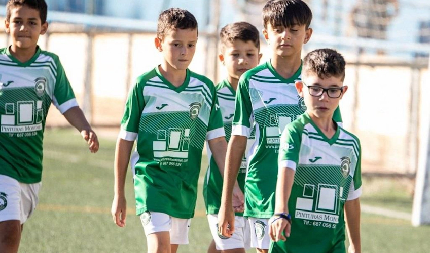 Молодые игроки в зеленой форме на футбольном турнире Spain Esei Cup.