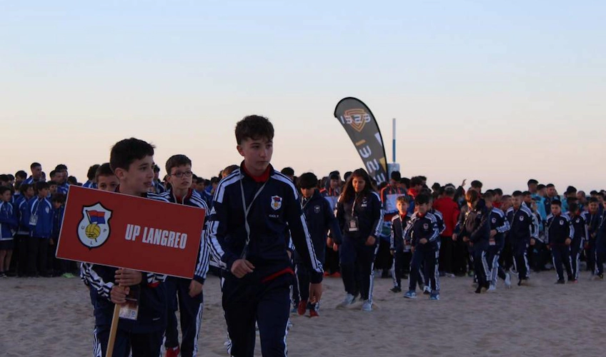 Юные футболисты с плакатом UP LANGREO на турнире Xixón Esei Cup.