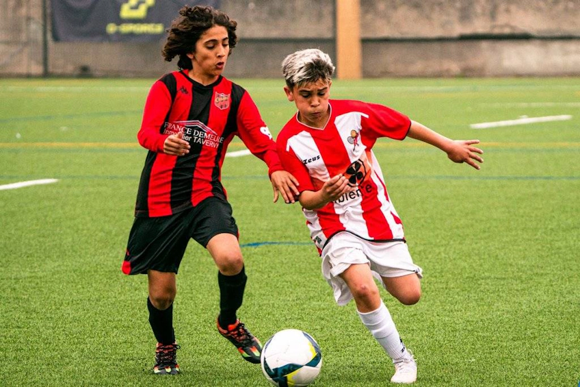 Два юных футболиста соревнуются за мяч на турнире Porto International Cup