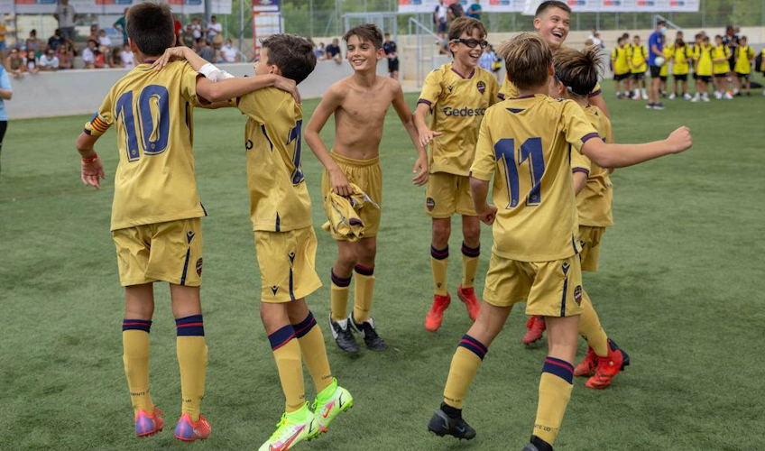 Altın formalı genç futbol takımı sahada bir zafer kutluyor.