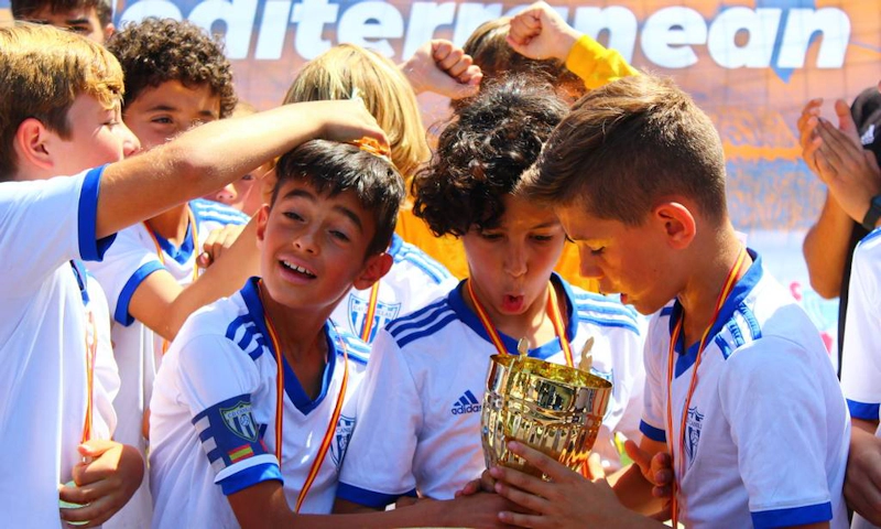 Young footballers kissing the trophy at the Mediterranean Esei Cup tournament