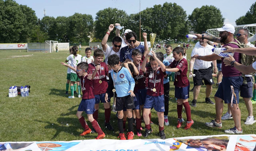 Детская футбольная команда празднует победу с трофеем на турнире Riccione Aquafan Trophy