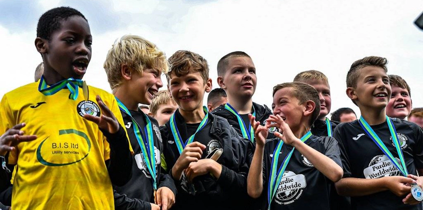 Юные футболисты с медалями на футбольном турнире The Edinburgh Cup