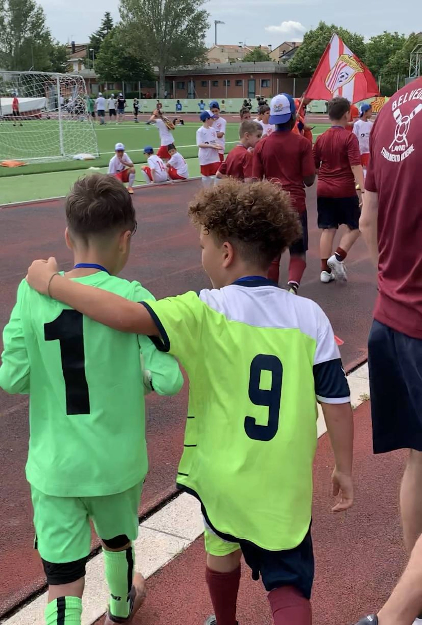 Riviera Cup futbol turnuvasında el ele yürüyen iki çocuk futbol formaları içinde