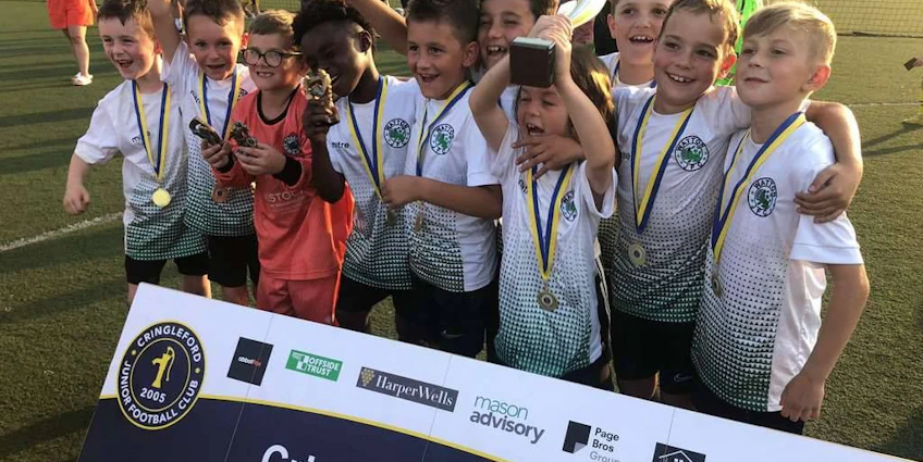 Юные футболисты с трофеем на Кубке Кринглфорда.