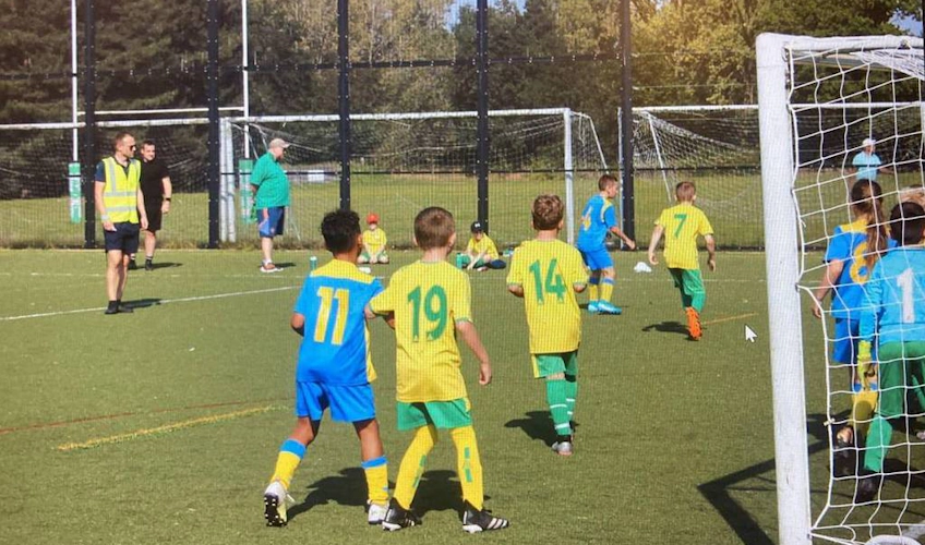 Cringleford Kupası'nda çocuk futbol maçı, gençler oynuyor.