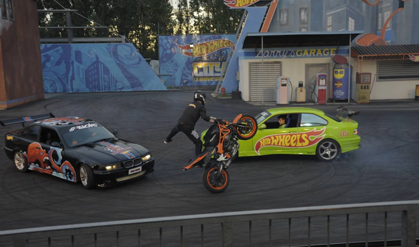 Eğlence parkı gösterisinde motosiklet akrobasyonları ve araba drifti
