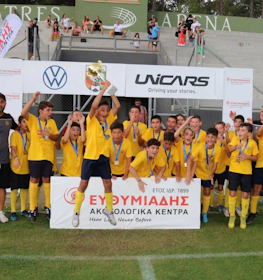 Equipe de futebol juvenil comemorando uma vitória no torneio Platres Summer Football Festival