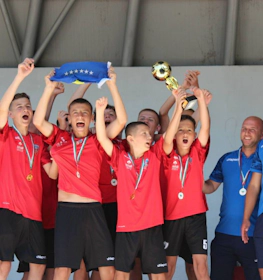 Jeunes footballeurs en maillots rouges célébrant une victoire au tournoi