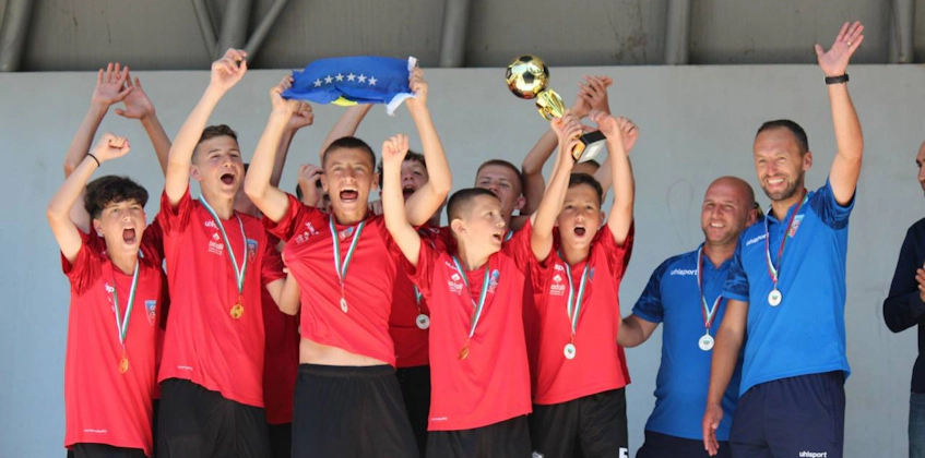 Kırmızı formalarıyla genç futbolcular turnuva zaferini kutluyor