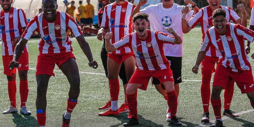 Jogadores de futebol em uniformes listrados de vermelho e branco comemorando uma vitória no campo
