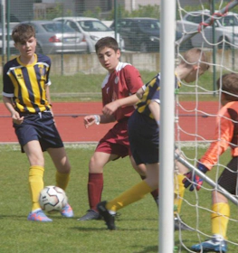 Jogadores de futebol adolescentes em jogo, goleiro pronto na trave