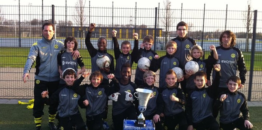 Equipe de futebol juvenil com troféu no torneio Young Talents Cup