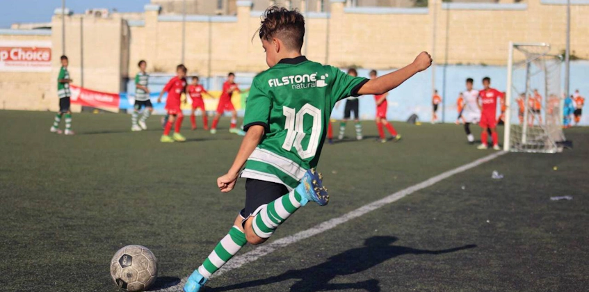 Yeşil forma giyen 10 numaralı genç oyuncu U14 KHS Kupası'nda top sürüyor
