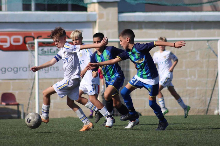 U14 KHS Kupası'nda top için mücadele eden genç oyuncular