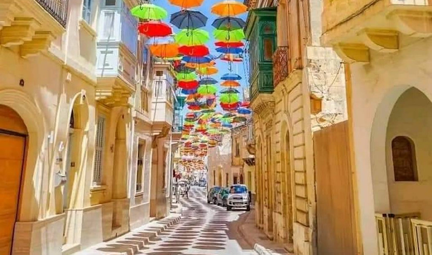 Tarihi bir şehirde renkli şemsiyelerle süslenmiş sokak