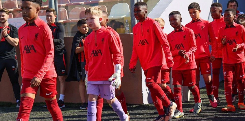 Детская футбольная команда в красной форме идет по полю на турнире U10 KHS Cup