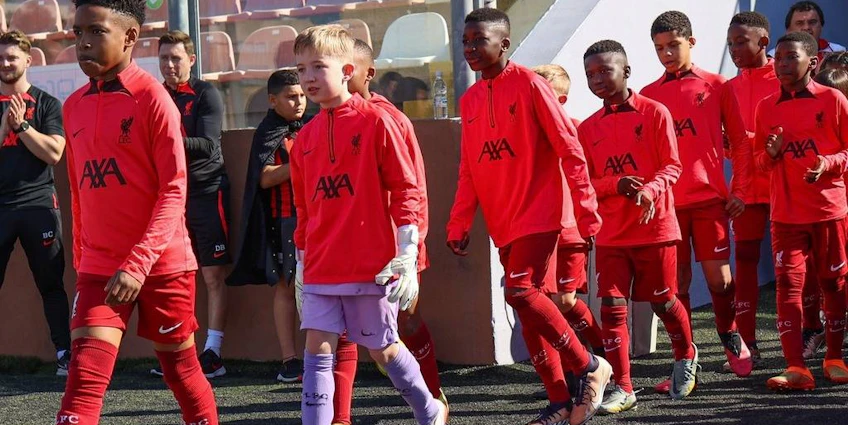 Équipe de football de jeunes en tenues rouges marchant sur le terrain à la U10 KHS Cup