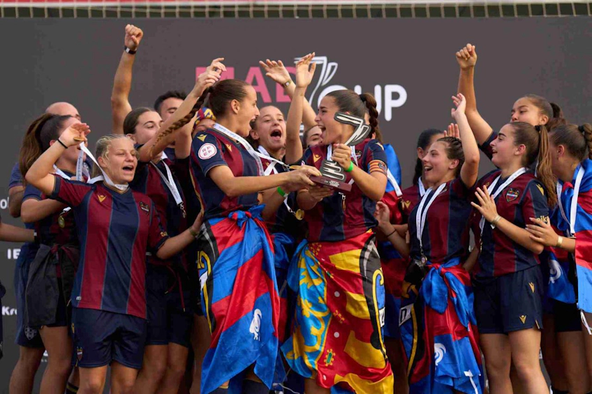 Женская футбольная команда радуется победе с трофеем на турнире MADCUP