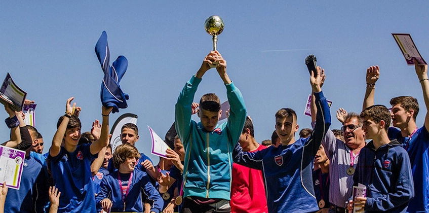 Футбольная команда празднует победу с трофеем на Salonica Soccer Cup