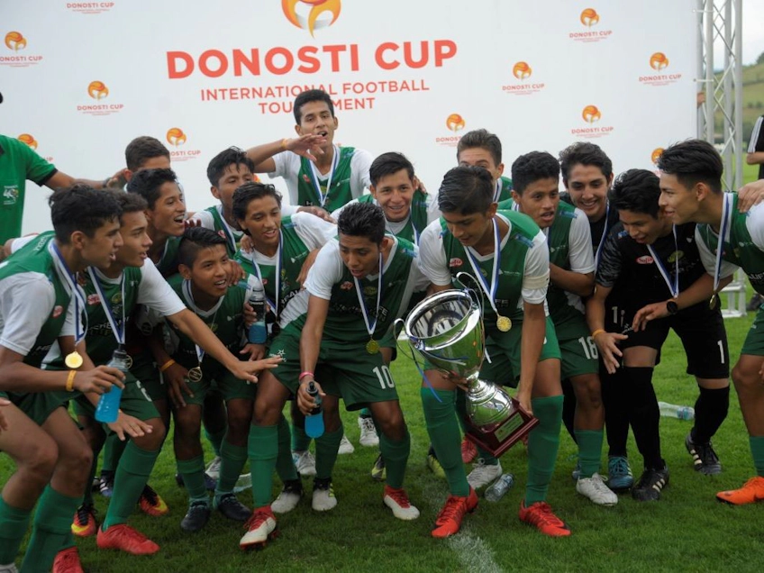 Юные футболисты празднуют победу с трофеем на Donosti Cup