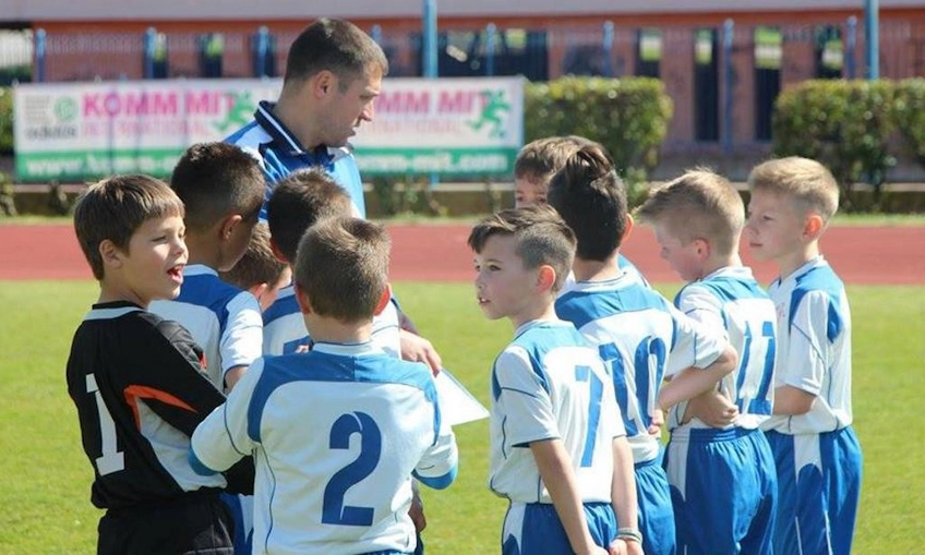 Antrenör, Istria Kupası turnuvasında genç futbolcularla stratejiyi tartışıyor