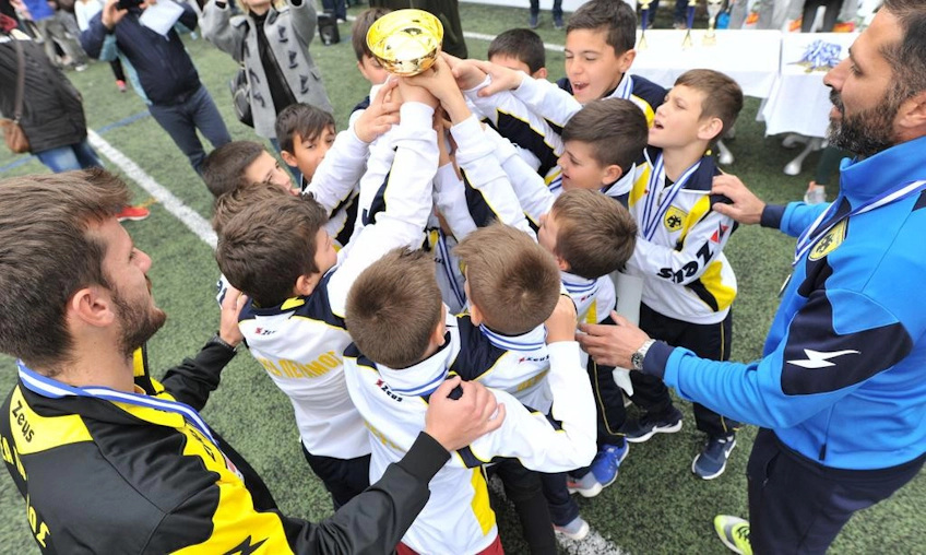 Юные футболисты празднуют победу с трофеем на турнире
