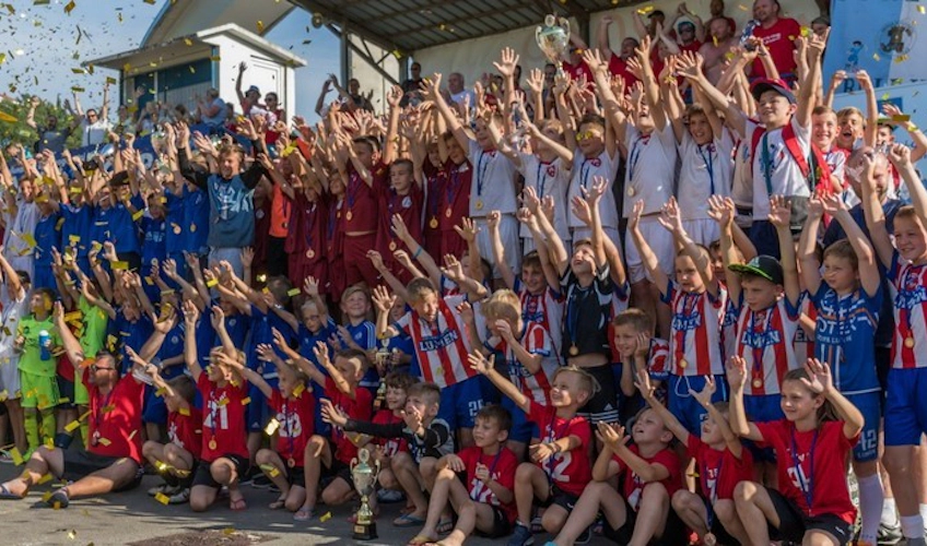 Юные футболисты и тренеры радуются победе на футбольном турнире